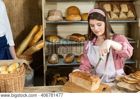 Before The Arrival Of Customers, The Baker Corrects The Arrangement Of The Bread And The Young Sales