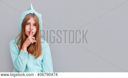 Pretty Girl Making Silence Gesture Over Gray Background