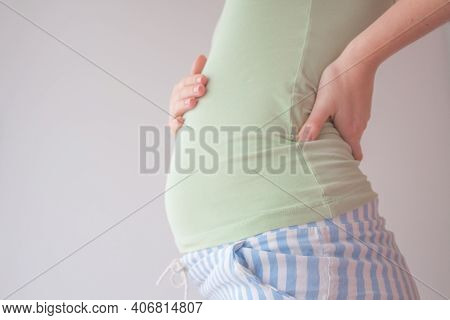 Pregnant Woman Holding Hands On Her Belly. Belly Of A Pregnant Woman On 16 Week, 4 Month. A Woman Is