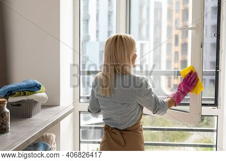 Smiling Black Woman Cleaning Windows With Glass Cleaner