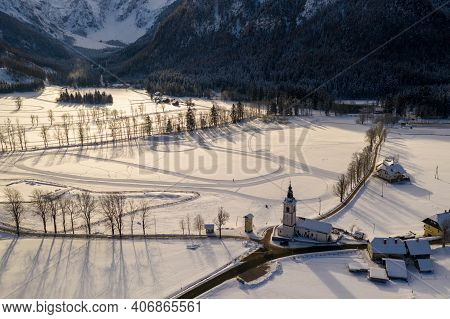 Aerial Winter Landscape With Mountain Village And Forest Covered In Snow. Zgornje Jezersko, Slovenia