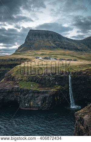 Gasadalur Village And Mulafossur Its Iconic Waterfall During Sunset In Summer With Bluw Sky. Vagar, 