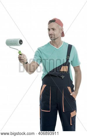 Paint And Renovate. Decorator Painting Wall. Man In Cap Hold Paint Roller White Background. Worker P