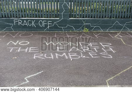 Anti-fracking Protest Written In Chalk On Street And Fence In Tauranga New Zealand.