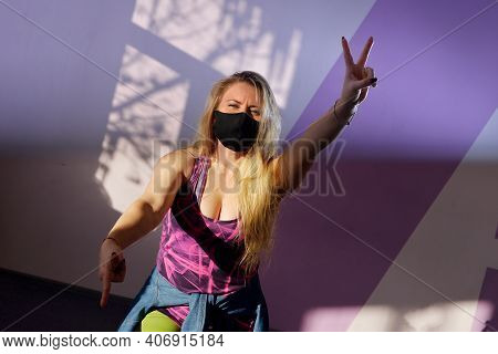 Young Blonde Girl Zumba Trainer Wears Black Mask During Pandemic