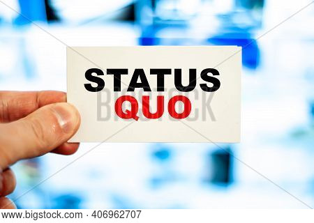 Concept Of A Person Holding A Business Card With The Words - Status Quo