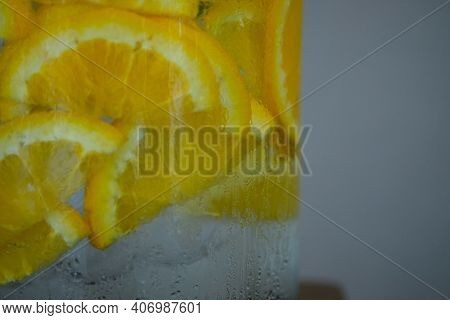 Drinking Water With Slice Of Oranges In Glass Tanka. Selective Focus