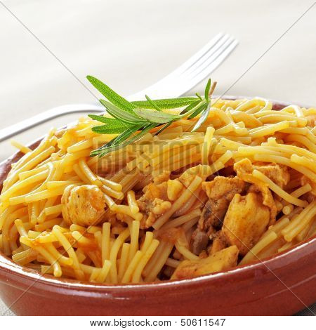 closeup of an earthenware bowl with spanish noodles with chicken