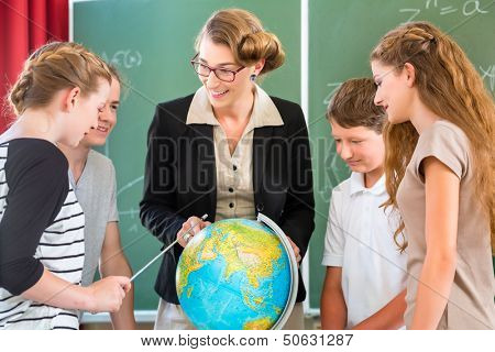 Students or pupils having group work while geography lesson and the teacher test or educate them in school or class