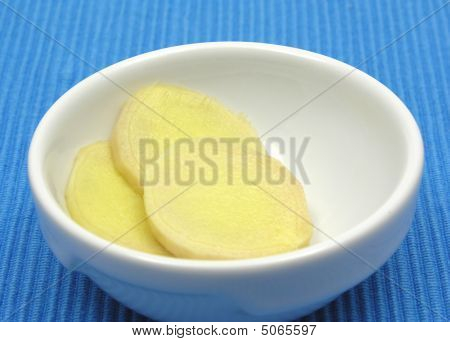 ขิงในชามของเครื่องลายครามบนพื้นหลังสีน้ำเงิน