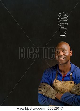 African Black Man Industrial Worker With Engery Saver On Blackboard Background African Black Man Ind