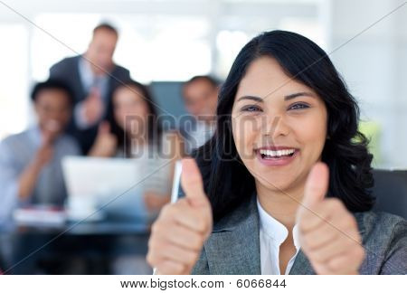 Retrato de una mujer de negocios con los pulgares para arriba en la oficina