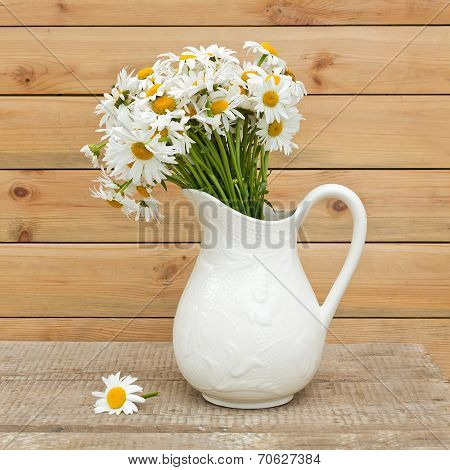 Bouquet Of Fresh  Daisies In Hite Jug On Wooden Background