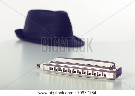 Still-life of hat and harmonica on white background
