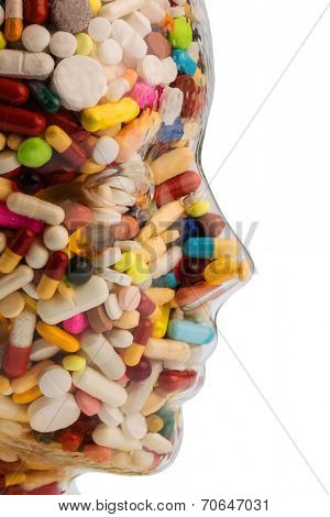 a head made of glass filled with many tablets. photo icon for drugs, abuse and addiction tablets.