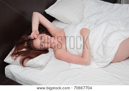 Smiling Young Woman Wakes Up On Bed