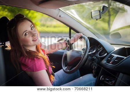 Beautiful smiling redhead woman traveling by car