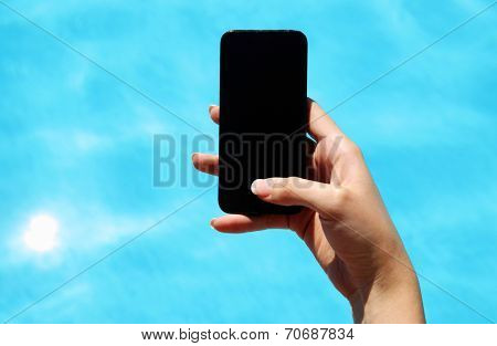 Closeup image of female hand using smartphone