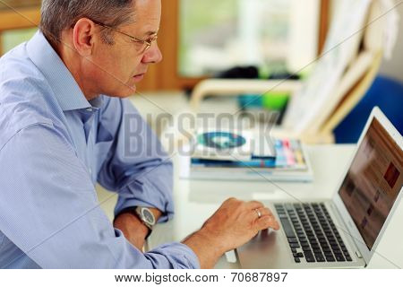 Portrait of senior caucasian man working on his laptop computer.