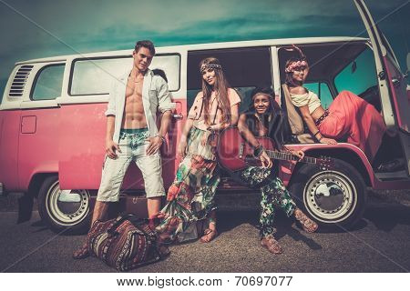 Multi-ethnic hippie friends with guitar on a road trip