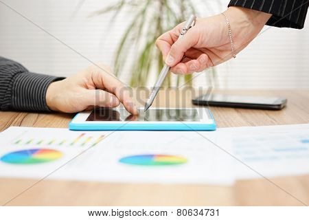Business People On Meeting Discussing Sales Report On Tablet Pc