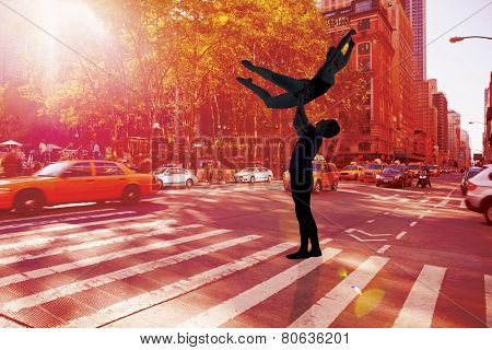 Ballet partners dancing gracefully together against new york street