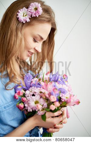 Beautiful girl looking at bunch of flowers