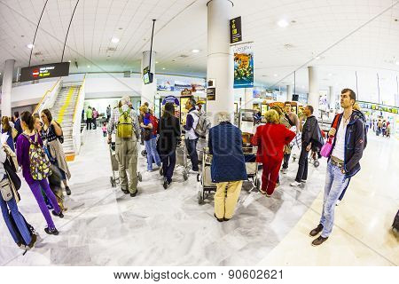 Tourists Wait For Their Baggage At The Airport