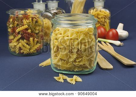 different kinds of pasta on the table, together with vegetables, ready for cooking