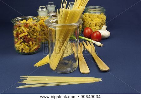 different kinds of pasta on the table, together with vegetables, ready for cooking