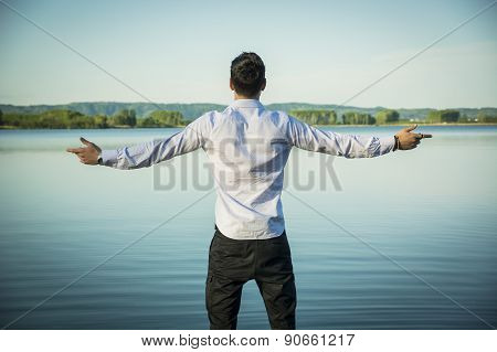 Young man outdoor with arms spread open enjoying freedom