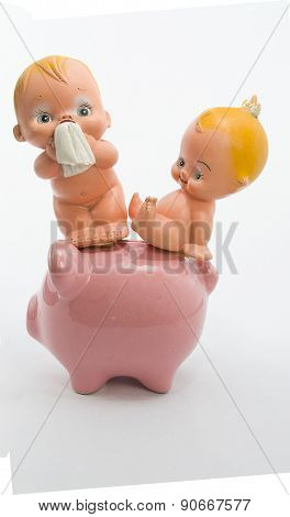 babys sitting on the floor with a piggy bank