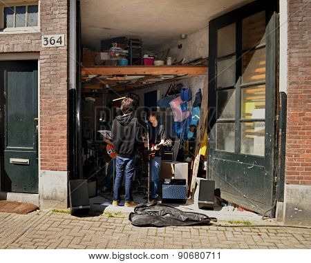 Young musicians are rehearsing in the garage.