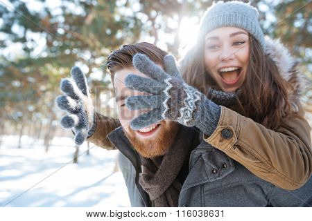 Cheerful young couple having fun in winter park
