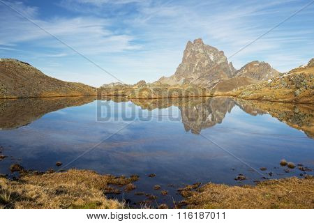 Midi Dossau Peak reflected in a lake. Ossau Valley, Pyrenees National Park, Pyrenees, France.