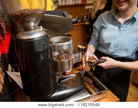 close up of woman making coffee by machine at cafe