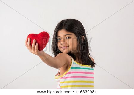 small girl with stuffed heart, stuffed heart and girl, indian girl holding stuffed heart, asian girl