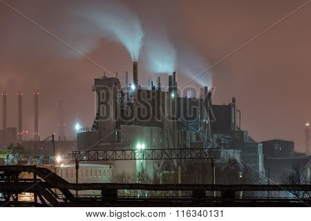 Power station with steam cloud blown by the wind in a cold starry winter night