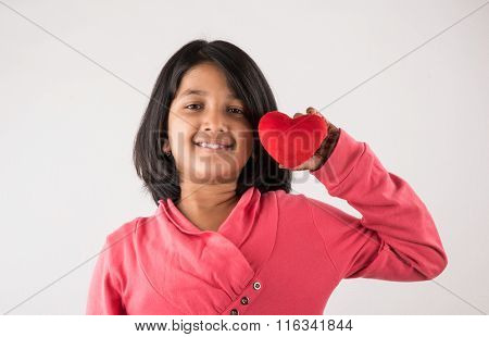 small girl with stuffed heart, stuffed heart and girl, indian girl holding stuffed heart, asian girl