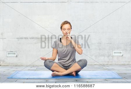 woman making yoga meditation in lotus pose on mat