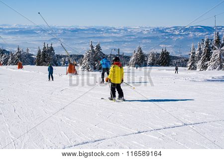 Ski slope, people skiing down the hill, mountains view