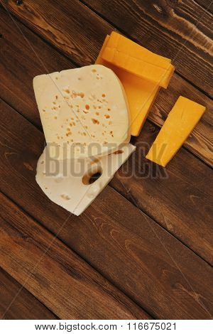 various types of fresh raw aged delicatessen cheese on wooden table cheddar edam swiss