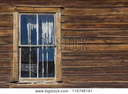 Window And Ripped Curtains Of A House In Bodie