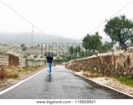woman walking on the road one rainy day