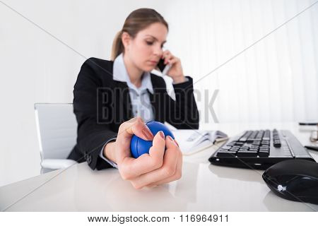 Businesswoman Pressing Stressball At Desk