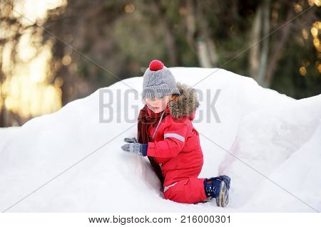 Little Boy In Red Winter Clothes Having Fun With Fresh Snow
