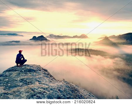 Moment Of Loneliness On Exposed Rocky Summit. Man In Black Enjoy Marvelous View. Hiker Sit On The Pe