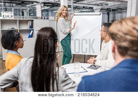 young manageress making presentaion with whiteboard for business partners