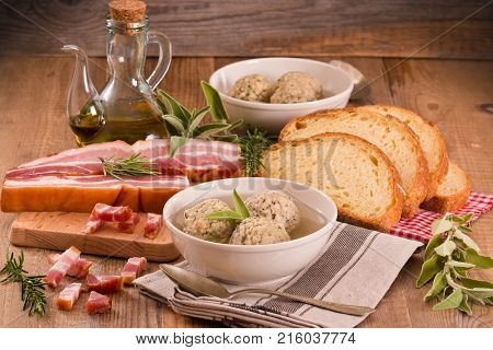 Canederli pasta with bacon on wooden table.