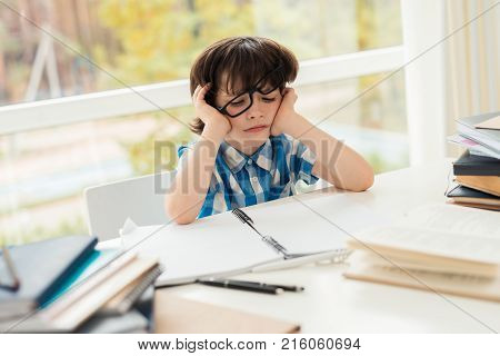 The schoolboy is tired of doing homework. He wants to walk. He was given a lot of homework.